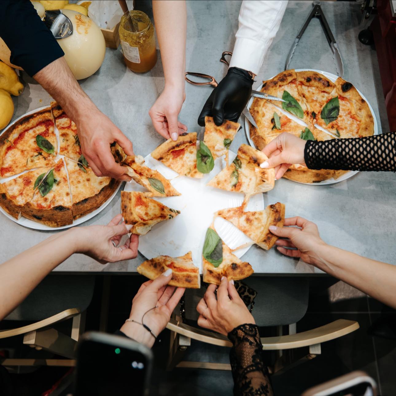 Prieteni împărțind pizza la Punto